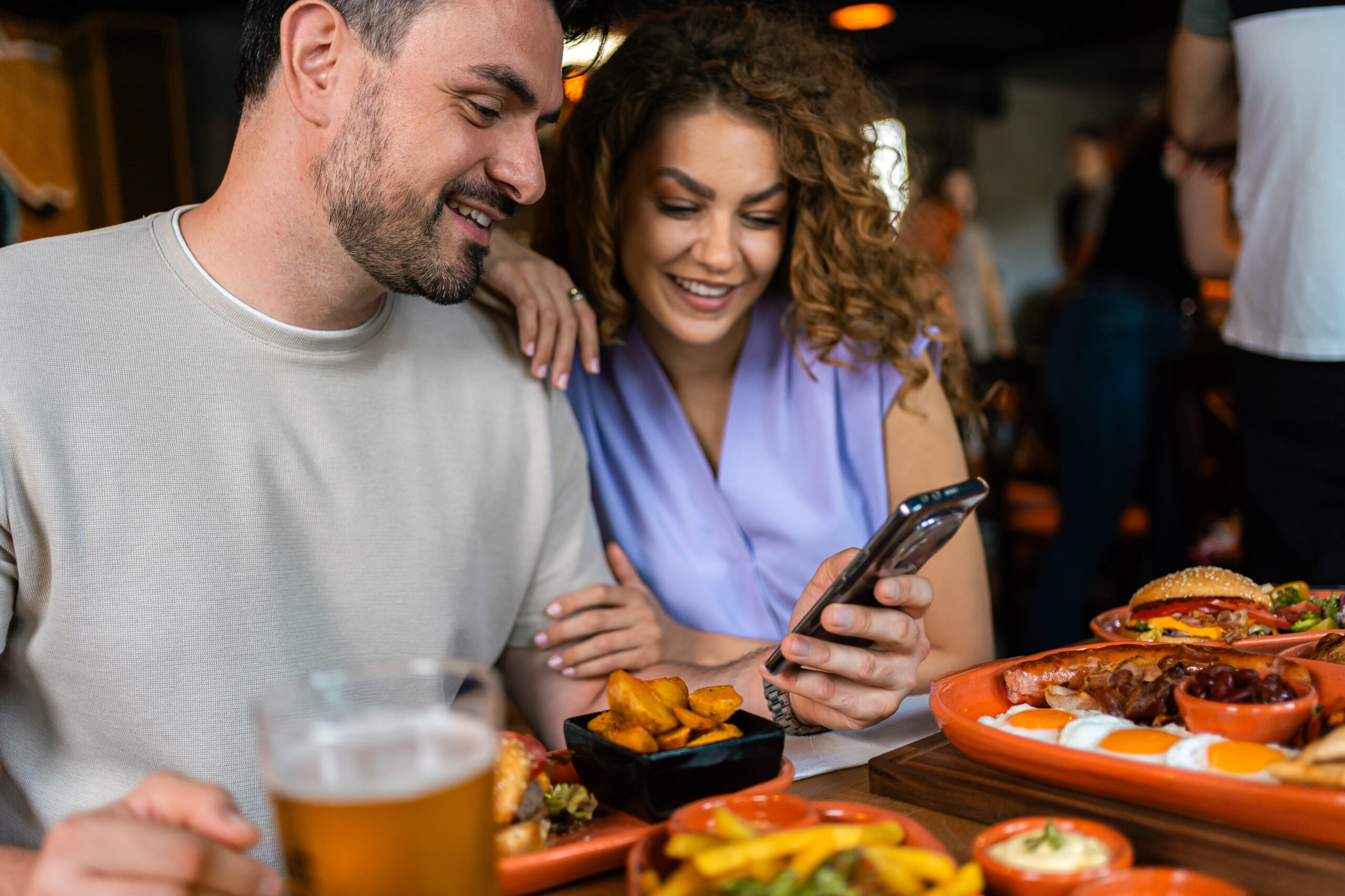 Couple at a restaurant looking at a loyalty reward received by SMS